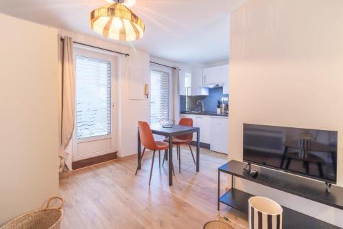 un salon avec une table, des chaises et une télévision dans l'établissement Quiet cocoon of love, à Toulouse