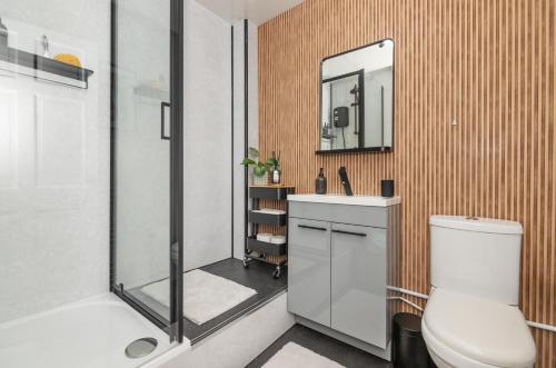 a bathroom with a shower and a toilet and a sink at Trendy 2 Bed Flat - Near Airport in Broxburn