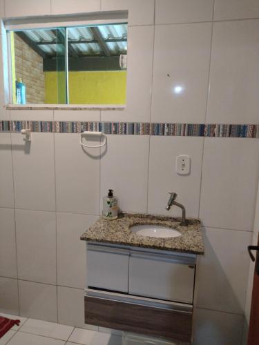 łazienka z umywalką i oknem w obiekcie Suite familiar w mieście Araruama