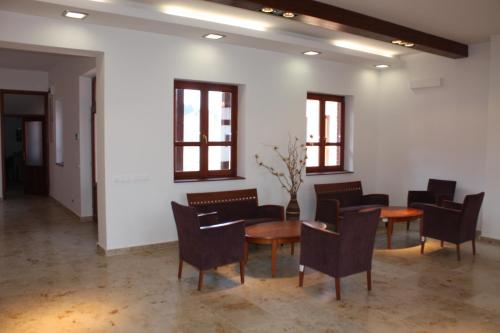 a waiting room with chairs and tables and windows at Naturpark Vendégház in Alsószölnök