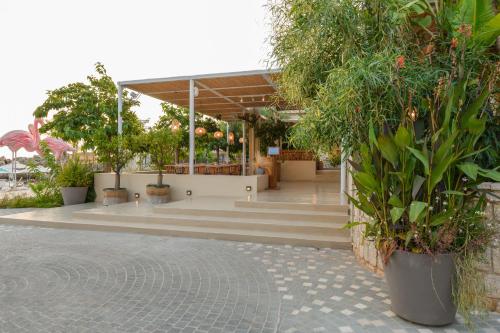 a group of potted plants and trees in a building at Folie Marine Hotel & Beach Club in Jal