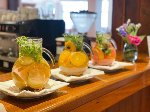 a wooden counter with three vases with fruit in them at Hotel Nahuel Huapi in San Carlos de Bariloche