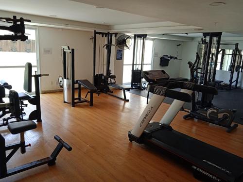 un gimnasio con varias cintas de correr y máquinas en una habitación en Flat na orla de Salvador, en Salvador