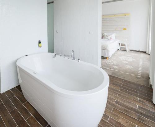 a white bath tub in a bathroom with a bedroom at Hotel Bonvino Badacsony in Badacsonytomaj