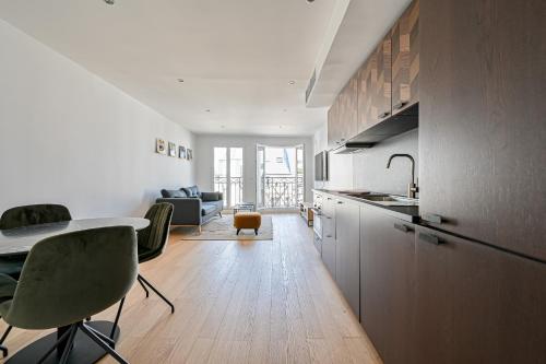une cuisine et un salon avec une table et des chaises dans l'établissement Terrasse au coeur du Marais, à Paris