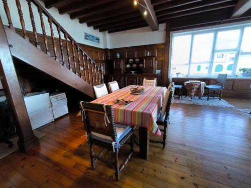 uma sala de jantar com uma mesa e uma escada em Exceptionnel-Spacieux-Vue mer Hendaye plage-Garage em Hendaye