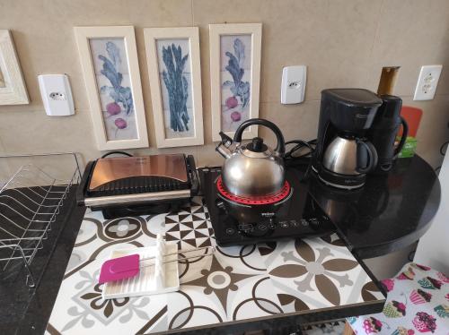 a kitchen counter with two tea pots on a stove at Odara, Pouso e Acolhimento in Pirenópolis