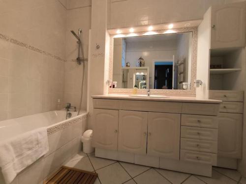 une salle de bain avec une baignoire, un lavabo et un miroir dans l'établissement Appt Exceptionnel-Spacieux-Vue mer Hendaye plage-Garage, à Hendaye