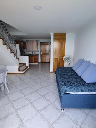 Un dormitorio con una cama azul y una escalera en Balcón del Infinito, en Santa Marta