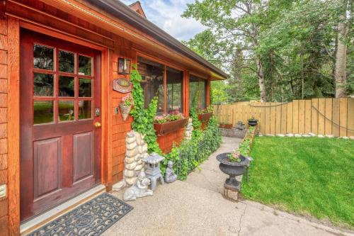 a house with a red door and a yard at B&B on Mountain Lane - Private Suite & Hot Tub in Banff