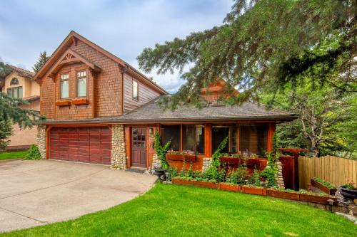 a house with a fence and a yard at B&B on Mountain Lane - Private Suite & Hot Tub in Banff