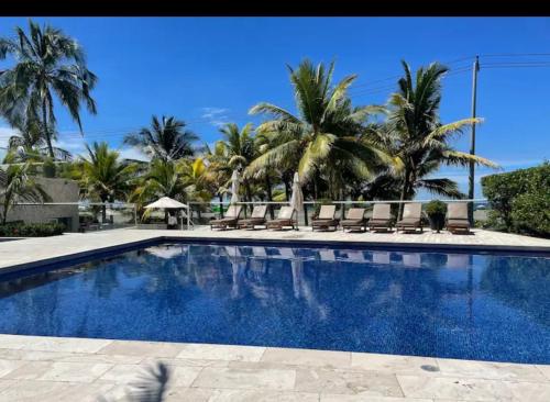una piscina con palmeras en el fondo en Apartamento de lujo en Morros Ultra, en Cartagena de Indias