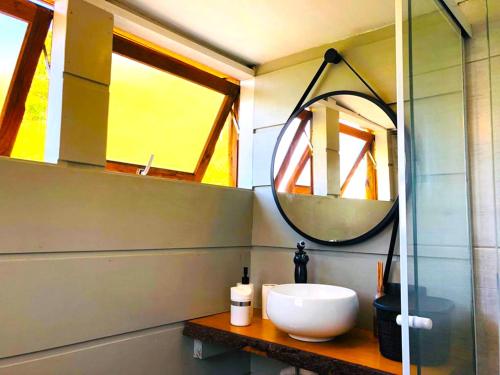 La salle de bains est pourvue d'un lavabo et d'un miroir. dans l'établissement Casa na árvore perto da praia, à Imaruí