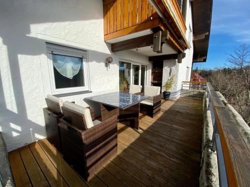a deck with a table and chairs on a house at Ferienwohnung Kobler in Görisried