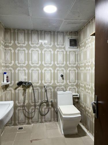 La salle de bains est pourvue d'une douche et de toilettes. dans l'établissement Tanih's Lodging, à Abu Dhabi