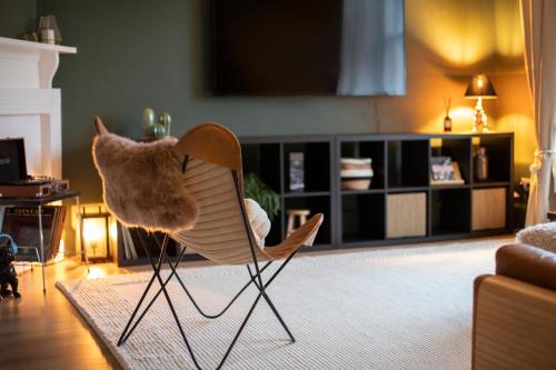 a chair with a stuffed animal sitting in a living room at Trendy 2 Bed Flat - Near Airport in Broxburn