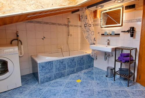 uma casa de banho com uma banheira, um lavatório e uma máquina de lavar roupa em Apartment Wegmo em Bischofshofen