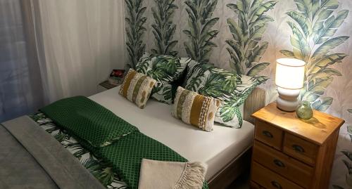 uma cama com um cobertor verde e almofadas em Przy Złotych Piaskach em Sława