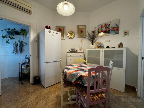 a kitchen with a table and a white refrigerator at Ruzzafa Codrut in Valencia