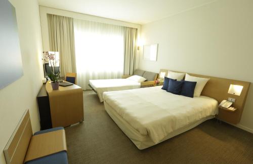 a hotel room with a large bed and a window at The Sydney Hotel in Bologna
