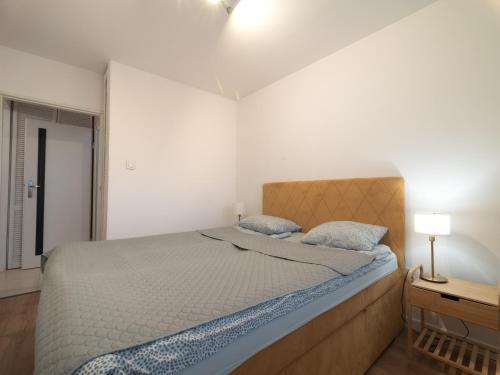 1 dormitorio con 1 cama grande y mesita de noche con lámpara en First Green Żoliborz apartament 7, en Varsovia