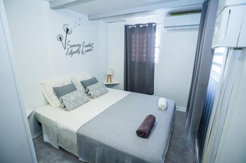 um quarto com uma cama com uma toalha em Au cœur du papillon piscine privée em Goyave