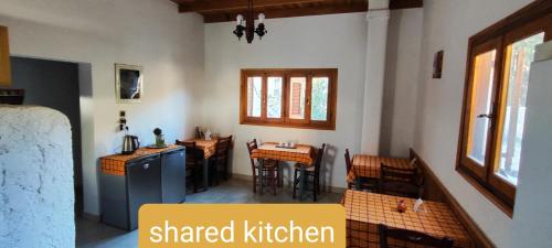aamed kitchen with tables and chairs in a room at Oleander's Garden Traditional Cretan Cottage in Ferma