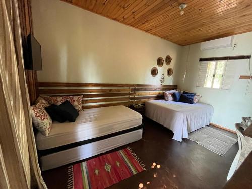 una camera da letto con due letti e un divano di Refúgio II Férias Incríveis ao Lado do Rio Iguaçu e Parque Nacional - Ideal para Casais e Amigos a Capanema