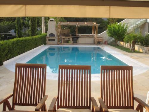 two chairs sitting next to a swimming pool at Luxurious Family friendly Villa Anavyssos in Anavissos