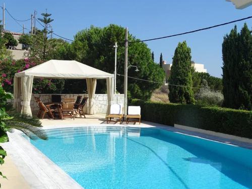 a swimming pool with a white umbrella and a table and chairs at Luxurious Family friendly Villa Anavyssos in Anavissos