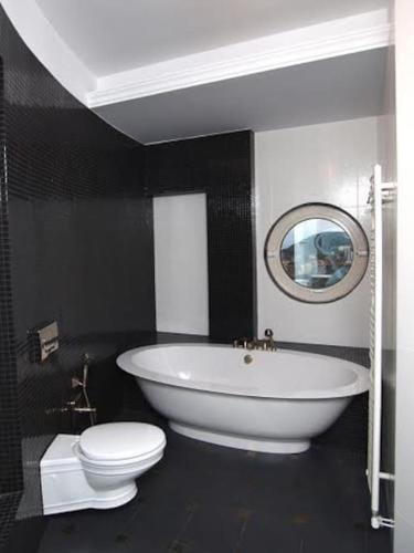 a bathroom with a white tub and a toilet at Luxurious Family friendly Villa Anavyssos in Anavissos
