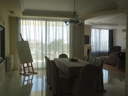 a room with a table and chairs and a living room at Luxurious Family friendly Villa Anavyssos in Anavissos