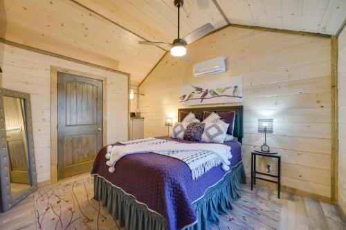 a bedroom with a bed in a room with wooden walls at Cozy Broken Bow Cabin Fire Pits, Community Spaces in Broken Bow