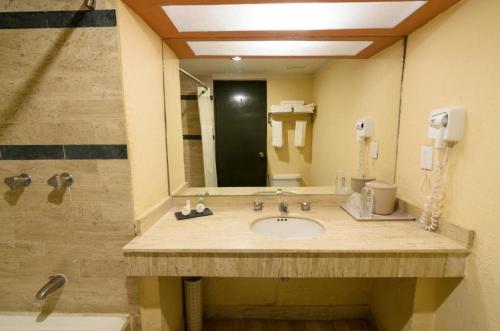 a bathroom with a sink and a shower and a mirror at Meson Sonora in Nuevo Laredo