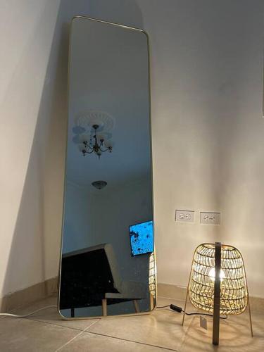Cozy apartment in AlOlaya Khobar في الخبر: مرآة في غرفة بها كرسي وتلفزيون