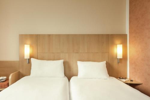 two beds sitting next to each other in a room at ibis Loriol Le Pouzin in Le Pouzin