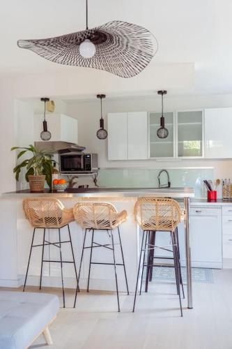 une cuisine avec deux tabourets de bar et un comptoir dans l'établissement Appartement Terrasse et Parking, à Aix-en-Provence