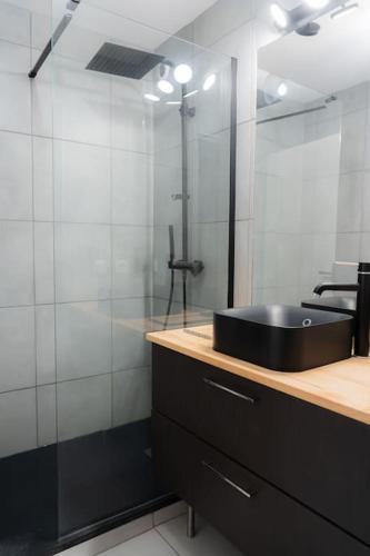 une salle de bain avec un lavabo noir et un miroir dans l'établissement Appartement Terrasse et Parking, à Aix-en-Provence
