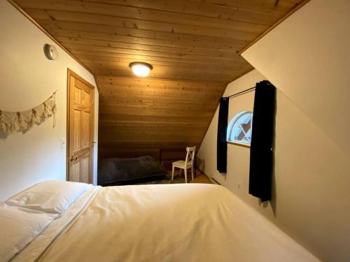 een slaapkamer met een bed in een houten kamer bij Cozy Alaskan Log Home - Aurora overhead in Fairbanks
