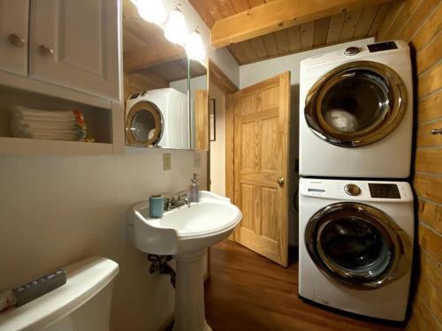 La salle de bains est pourvue d'un lave-linge et d'un lavabo. dans l'établissement Cozy Alaskan Log Home - Aurora overhead, à Fairbanks