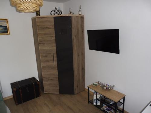 un grand meuble en bois avec une télévision murale dans l'établissement Gîte Amande Domaine de L'Annonciade, à Les Mées