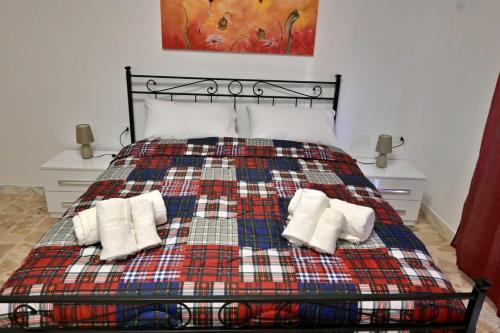 a bedroom with a bed with a plaid blanket at Luminosa casa punti cardinali in Siracusa