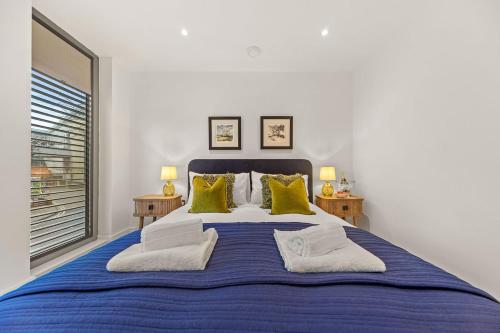 a bedroom with a large blue bed with yellow pillows at Atlas House Three in Harrogate