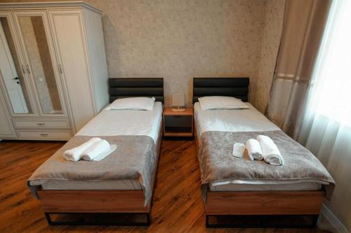 two twin beds in a room with wooden floors at Lunisi Kvareli in Kvareli