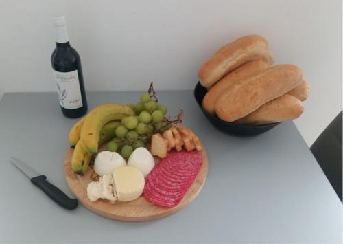 a plate of food with eggs and bread and a bottle of wine at Sommer Apartment in Entroncamento