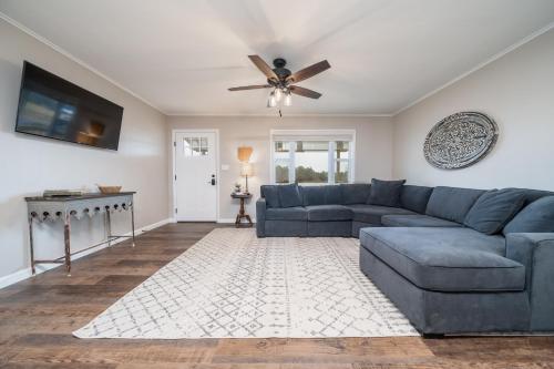 a living room with a blue couch and a ceiling fan at Nordins Hillside Meadow View Cabin in Coffeyville