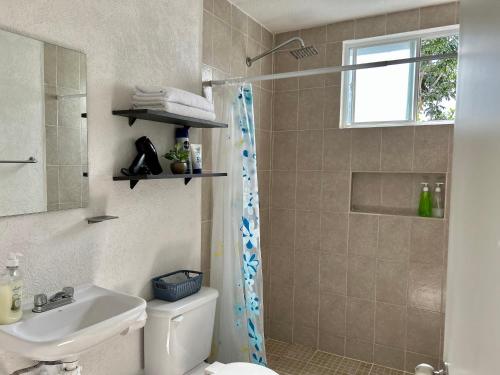 y baño con ducha, aseo y lavamanos. en Departamento 2 habitaciones alberca Luna by Eita, en Cancún
