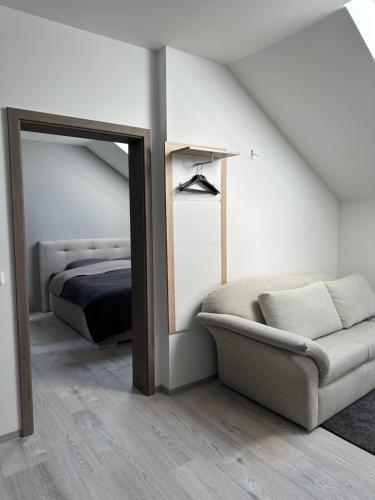 a bedroom with a bed and a couch and a mirror at Zwillinge Ferienwohnung am Markt in Finkenburg