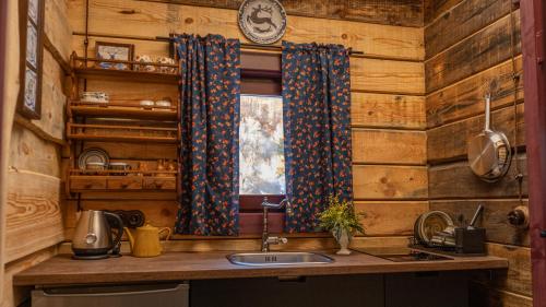 a kitchen with wooden walls and a sink and a window at Chalet Mountain Deer in Kolašin