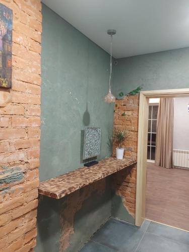 Zimmer mit einer Steinmauer und einem Holztisch in der Unterkunft Apartamentai poilsiui in Telšiai